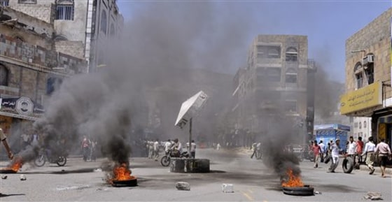Anti-government protesters block the road with rocks and burning tires during clashes with Yemeni security forces in Taiz, Yemen, on Tuesday. Heavy fighting resumed Tuesday in Yemen's capital between government troops and followers of the country's most powerful tribal leader, ending a brief cease-fire and again raising the prospect that Yemen's political crisis could veer into civil war.